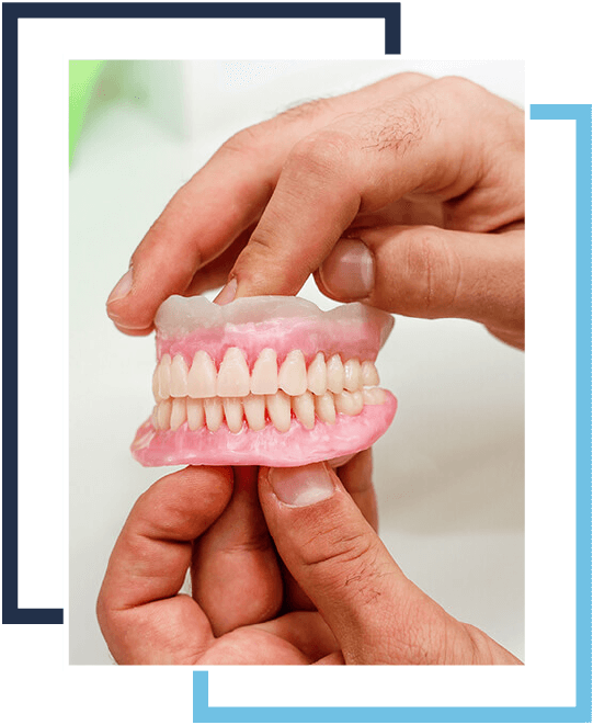 A person holding an artificial teeth in their hand.